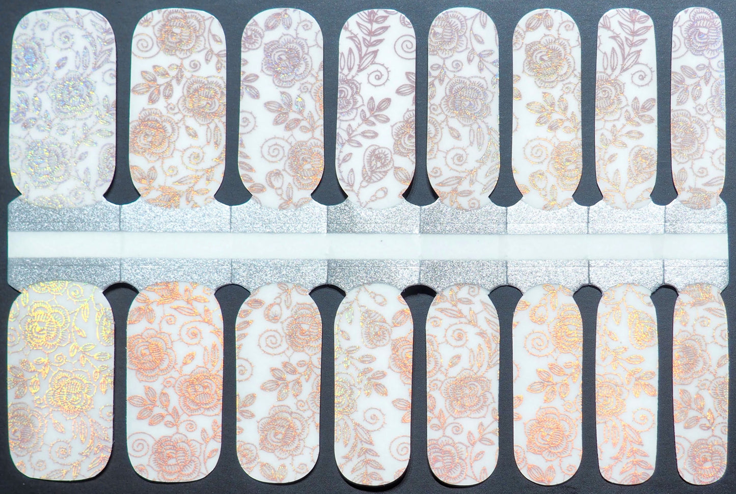Semi-transparent nail wraps with iridescent rose patterns and gold accents.