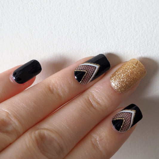 Black and gold nail wraps with semi-transparent chevron accents