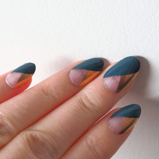 Semi-transparent nail wraps provide high contrast between smoky teal and gold.
