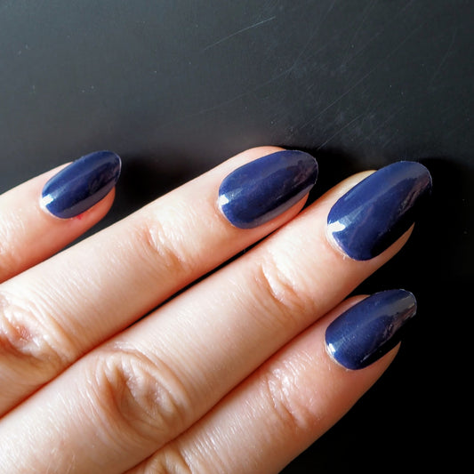Deep navy blue nail wraps on oval nails.