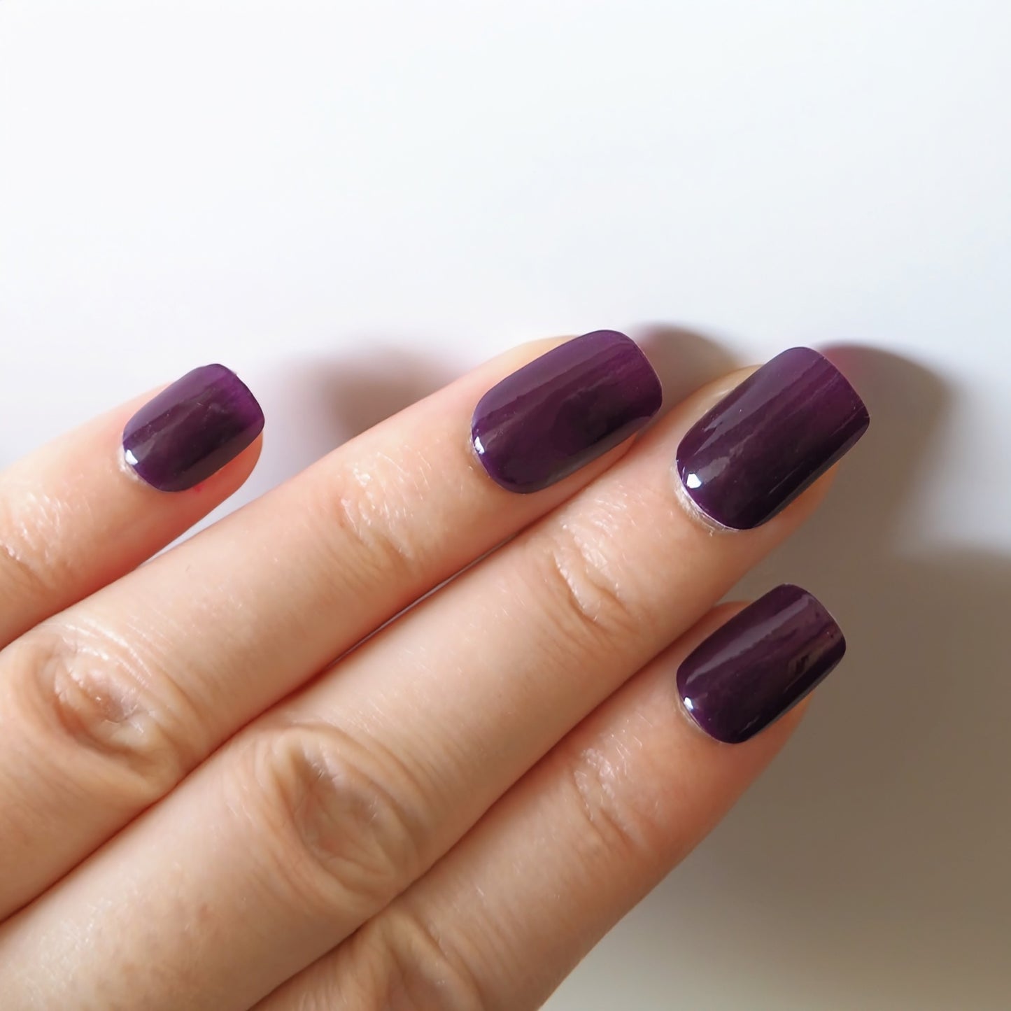 Rich plum purple nail wraps on square nails.
