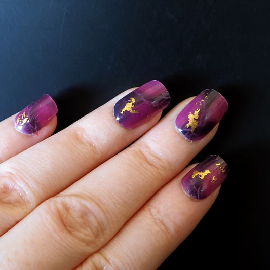 Purple marble-patterned nail wraps on square nails.