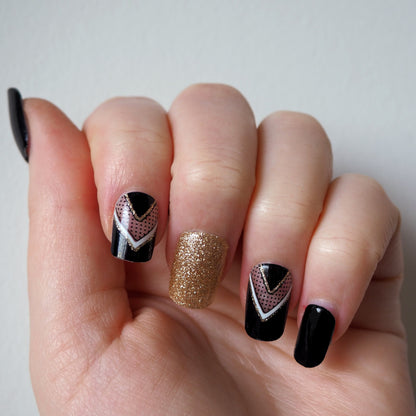 Peak through to the natural nail with these semi-transparent gold and white chevron accents on a black base.