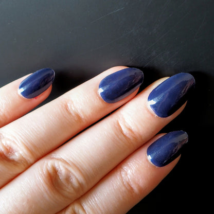 Deep navy blue nail wraps on oval nails.