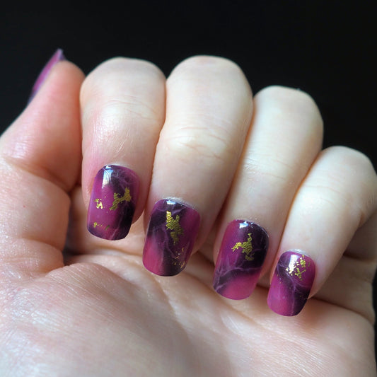 Royal Marble nail wraps with purple and gold marble pattern applied to nails.